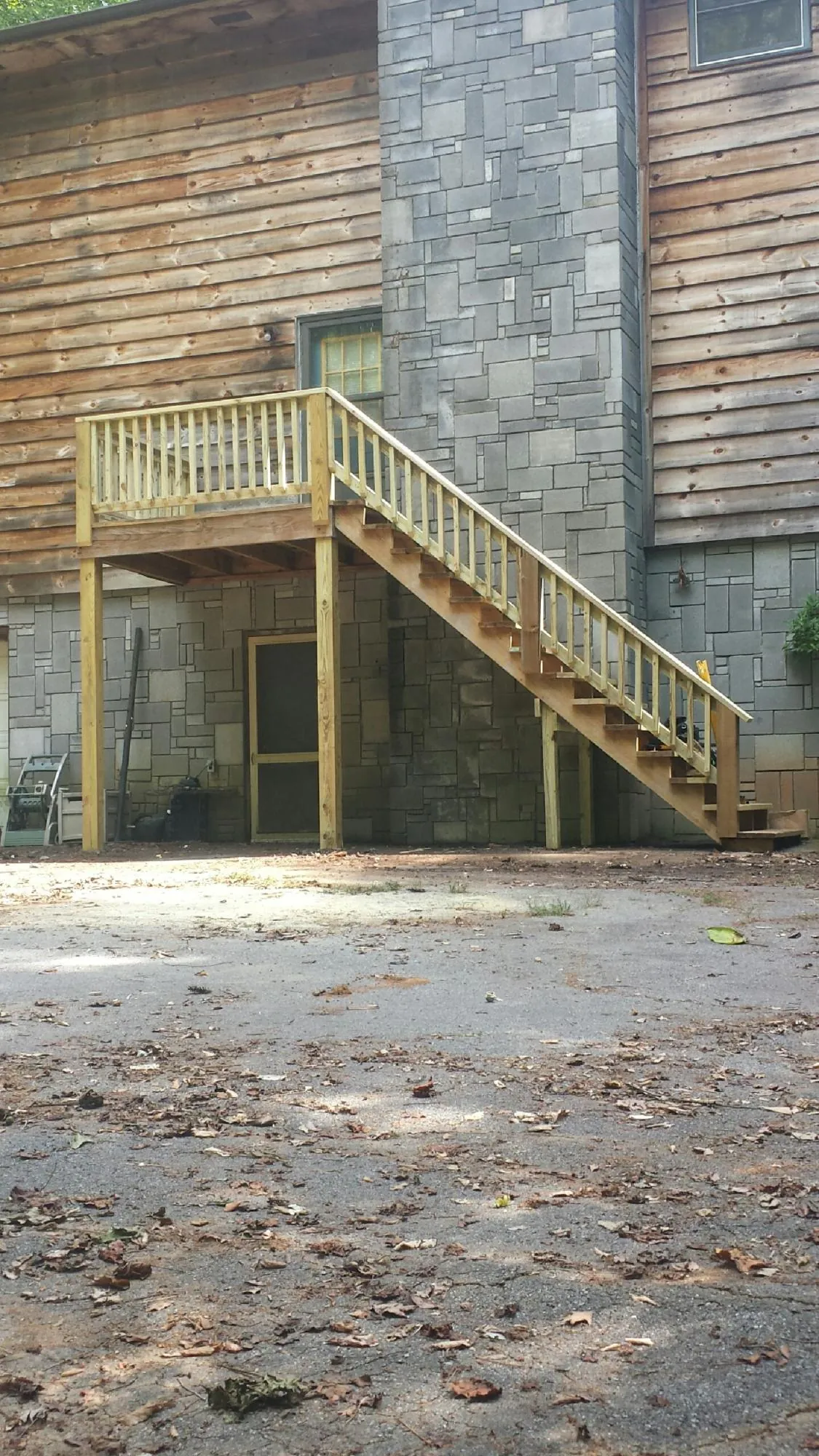 New pressure treated deck and stair landing on a log home in Millbrook
